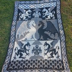 a black and white rug on the ground with horses, lions, and other animals