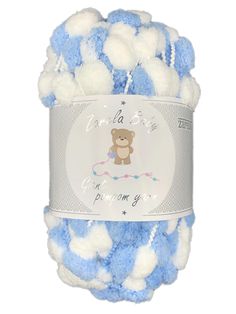 a ball of blue and white yarn with a teddy bear on the top, in front of