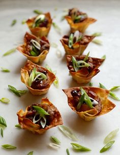 small appetizers are arranged on a white surface