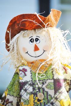 a close up of a doll wearing a scarecrow hat and dress with white hair