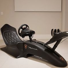 a black car with steering wheel and pedals on the floor