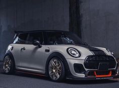 a white and black mini cooper parked in front of a building