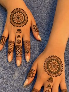 two hands with henna tattoos on them