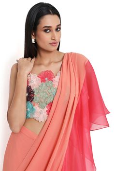 Peach georgette 3D floral embroidered choli and peach georgette saree with coral organza ruffle pallu. Disclaimer: Since we are a made-to-measure brand and our dyeing process and embroidery are handcrafted, there may be slight variations in the color and embroidery of the actual product. The print placement may also vary from what is represented in the images shown on the product page. Pink Traditional Drape Blouse For Summer, Summer Pre-draped Georgette Saree With Sheer Dupatta, Summer Georgette Pre-draped Saree For Reception, Summer Georgette Choli, Pink Pre-draped Saree For Summer, Reception Blouse With Floral Embroidery In Georgette, Reception Georgette Blouse With Floral Embroidery, Orange Georgette Choli For Reception, Elegant Georgette Choli For Spring