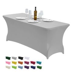 a white table cloth with wine bottles and glasses on it, all in different colors