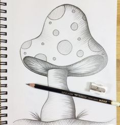 a pencil drawing of a mushroom sitting on top of a piece of paper next to a marker