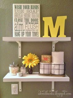 a bathroom shelf with towels and other items on it, including a yellow letter m