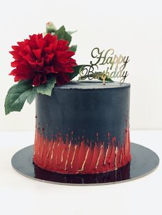 a red and black cake with a flower on top