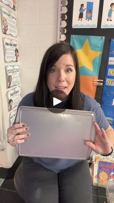 a woman sitting on the floor with her laptop in front of her face and making a funny face