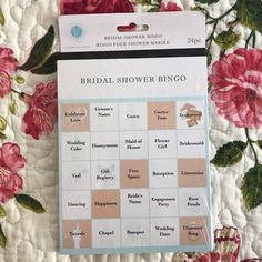 the bridal shower bingo game is sitting on a bed with pink flowers and green leaves