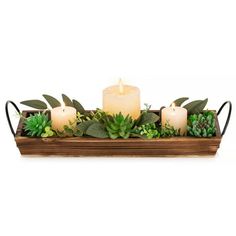 a wooden tray with candles and succulents in it on a white background