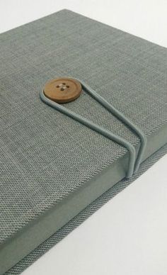 a book with a wooden button on the front cover and an elastic cord attached to it