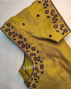 an embroidered yellow sari with black and gold embroidery on the border, along with a matching blouse