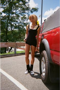 a woman standing next to a red truck