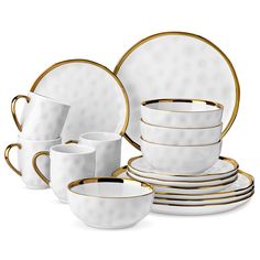 white and gold dinnerware set with matching cups, saucers, and spoons