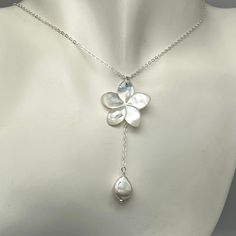 This necklace is a simple but elegant look with a lustrous carved white mother of pearl flower accented with a single iridescent freshwater teardrop pearl. There are beautiful tones of light pink and silver in the pearl and flower. The necklace is made with delicate sterling silver chain. It can be made in different lengths. The flower is approximately one inch in size. The chain and pearl hand down approximately 2 1/4 inches from the top of the flower to the bottom of the pearl. This length can be adjusted if needed with a message. There is a pair of matching earrings at the following link, https://www.etsy.com/listing/1381652571/white-mother-of-pearl-plumeria-earrings?click_key=af15be3310df952f1b155bc15b7ce32de969aa3b%3A1381652571&click_sum=1cbe4a2d&ref=shop_home_active_1&clickFromShopCa Beach Wedding Necklace, Ethereal Jewelry, Y Necklace, Mother Of Pearl Necklace, Pink And Silver, Minimalist Gifts, Jewelry Lookbook, Pearl Flower, Jewelry Inspo