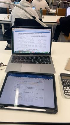 two laptops sitting on top of a white table