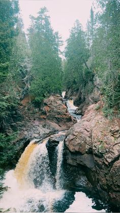 a small waterfall in the middle of a forest