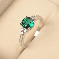 Round Emerald Engagement Ring, Silver Emerald Ring With Prong Setting, Dazzling Silver Emerald Ring With Prong Setting, Dazzling Emerald Ring With Halo Setting For Promise, Anniversary Emerald Cluster Ring With Birthstone, Emerald Diamond Promise Ring, Emerald Ring With Prong Setting In Round Cut, Emerald Promise Ring With Center Stone, Promise Emerald Ring May Birthstone Round Cut