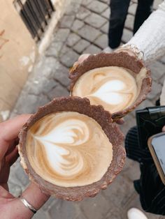 two people holding up some kind of dessert in front of each other on the street