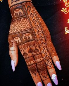 a woman's hand with henna tattoos on it and an elephant design on the palm