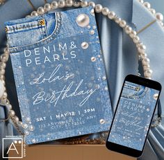 a cell phone sitting next to a book and pearls on a blue cloth covered chair