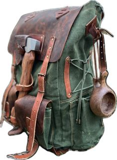 an old green backpack with leather straps and tools attached to the back, on a white background