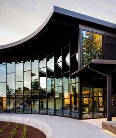 a curved building with many windows on the front and side walls, along with steps leading up to it