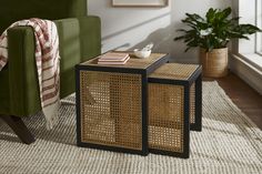 two side tables sitting on top of a rug next to a green chair