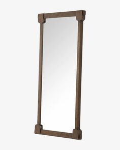 a wooden mirror sitting on top of a white wall