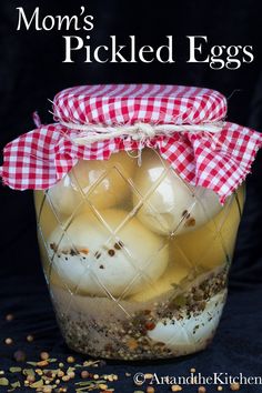 a jar filled with lots of food sitting on top of a black table next to seeds