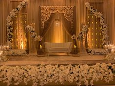 a decorated stage with white flowers and candles