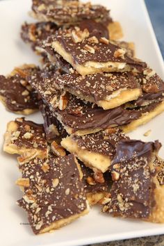 a white plate topped with chocolate covered pretzels and pecans on top of it