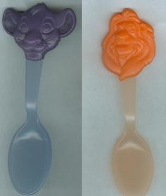 two plastic spoons with faces on them, one is orange and the other is purple