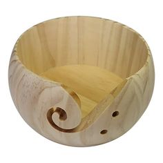 an unfinished wooden bowl with holes in the middle and a spiral design on the side