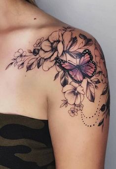 a woman with a butterfly tattoo on her shoulder and chest is looking at the camera