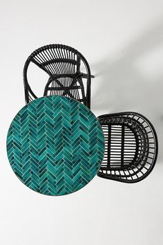 two wicker chairs and one black chair with green cushion on white background, side by side