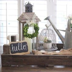 a wooden tray with flowers, watering can and a sign that says hello on it