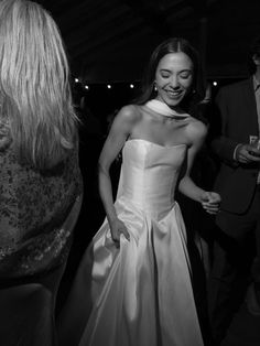 a woman in a white dress standing next to another woman