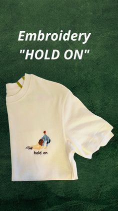 an embroidered t - shirt with the words hold on written in white and green ink