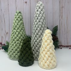 three crocheted christmas trees sitting next to each other