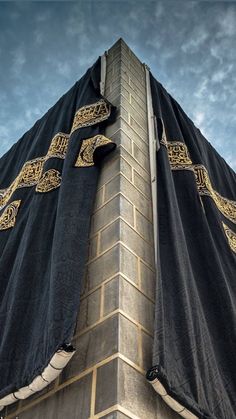 the top of a building with a black and gold cloth covering it's roof