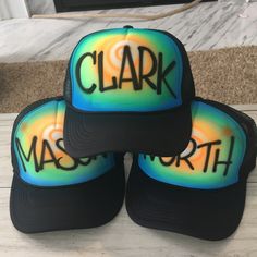 three hats with the word clark on them are stacked up in front of a fireplace