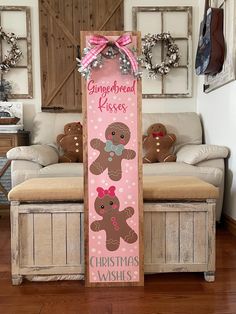 a wooden sign with gingerbread kisses on it in front of a couch and window