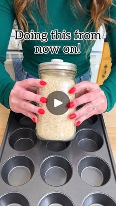 a woman holding a jar filled with oatmeal in front of muffin tins