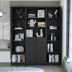 a black bookcase filled with lots of books next to a white bed and window