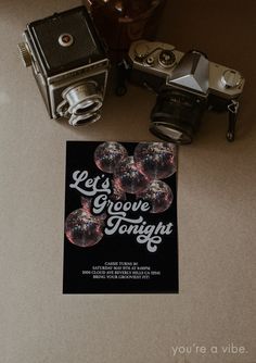 an old fashioned camera sitting on top of a table next to a card that says let's grooze tonight