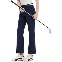 a woman is holding a golf club and wearing high waist blue pants with white stripes