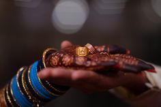 two hands holding wedding rings and bracelets