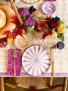 the table is set with plates, napkins and other decorative items for thanksgiving dinner